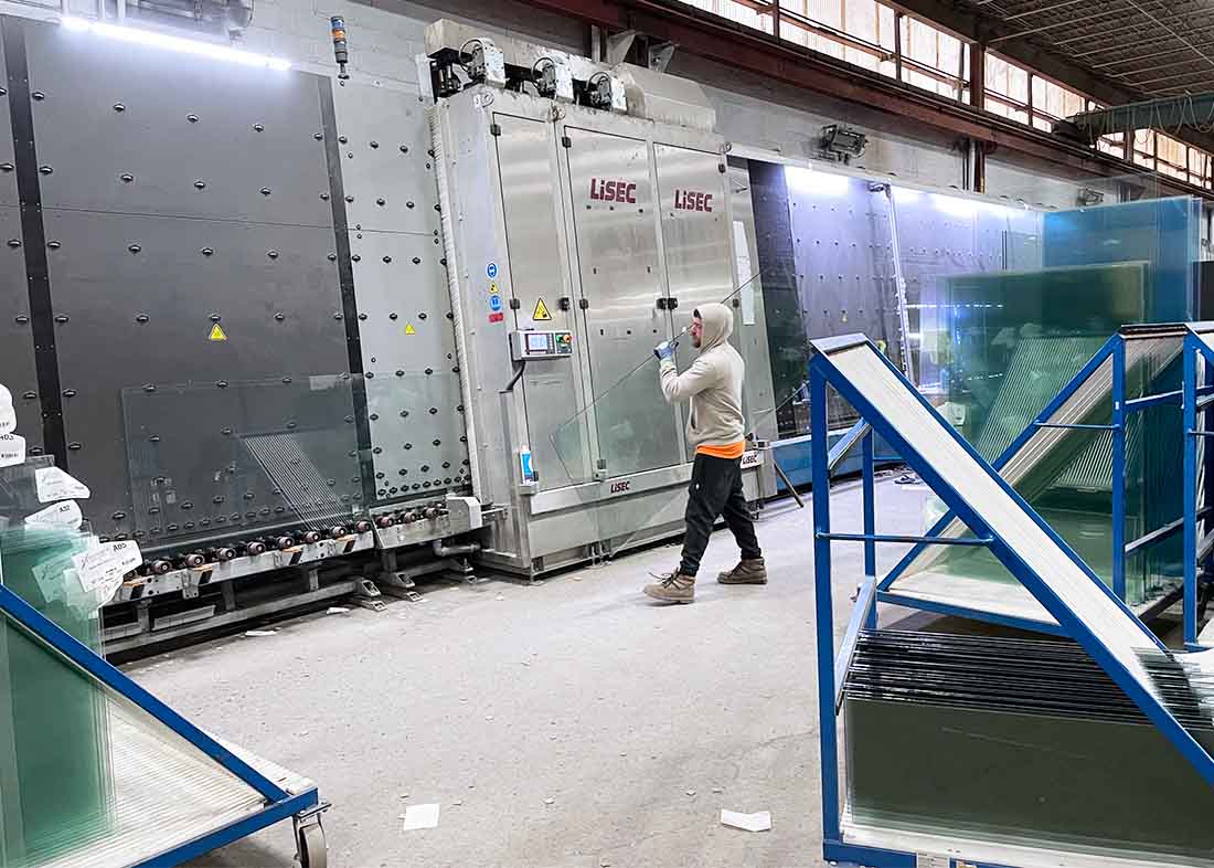 factory employee holding fabricated glass panel