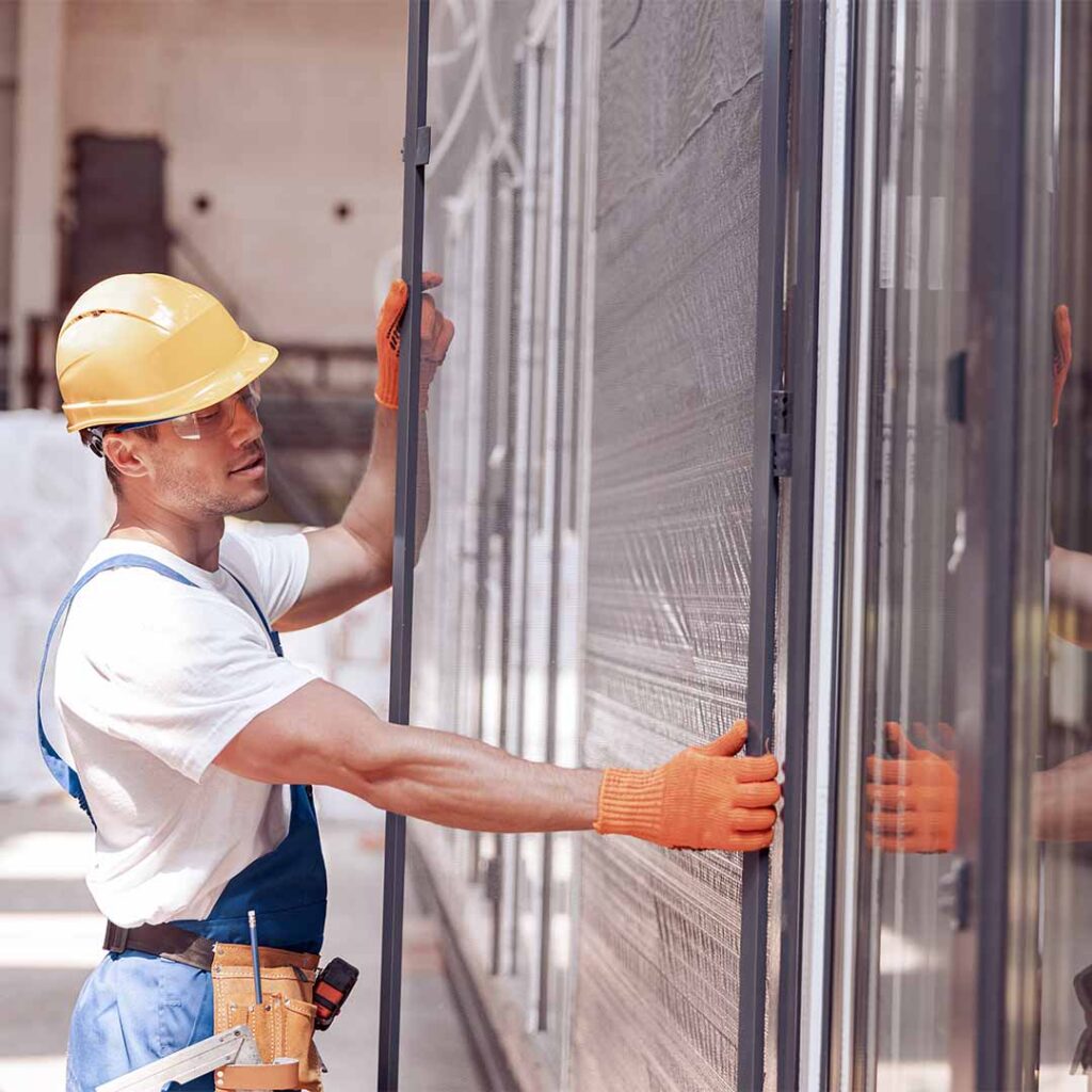 construction worker holding large sliding glass doors